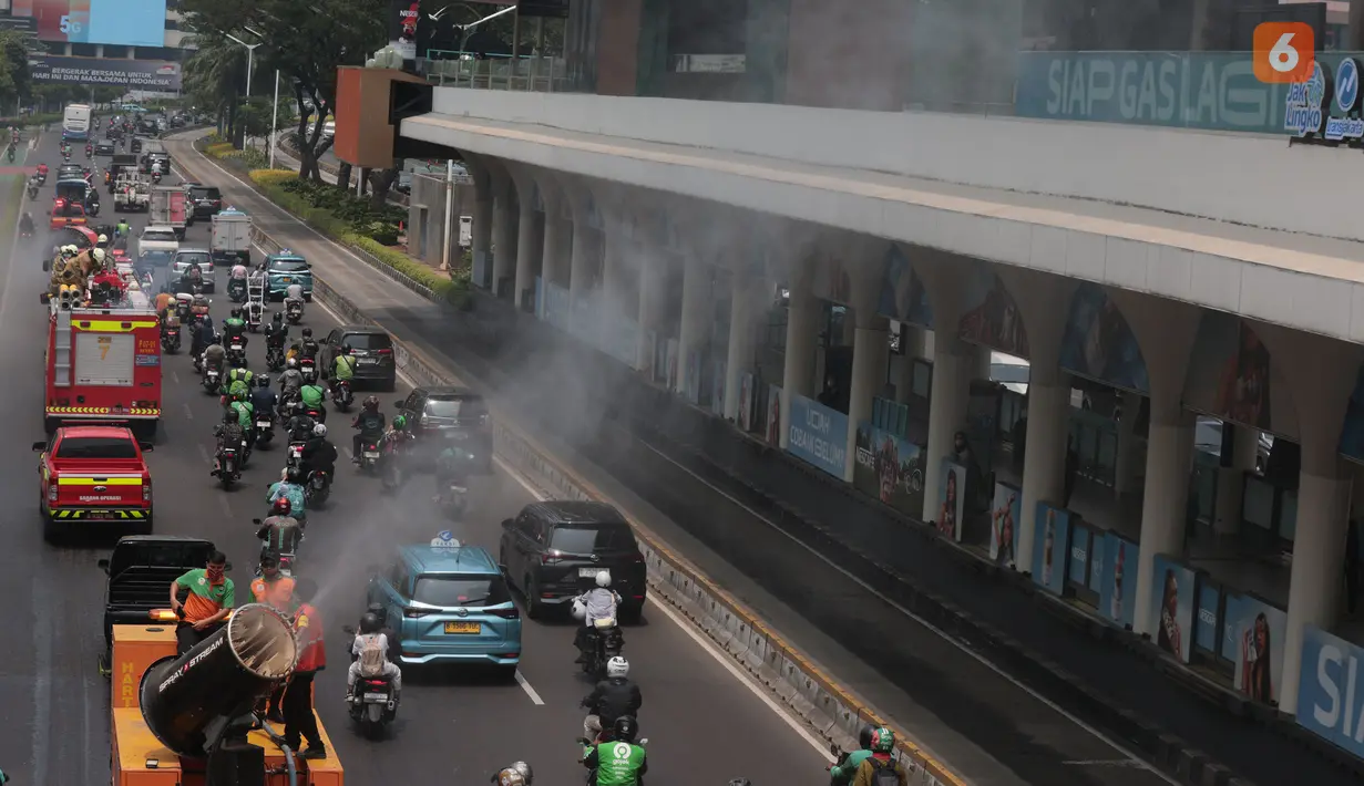 Petugas menyemprotkan air bertekanan tinggi ke permukaan jalan dalam operasi water mist untuk mengendalikan partikel debu akibat sebaran abu vulkanik Gunung Anak Krakatau di Jakarta. (KLY/Budy Santoso)