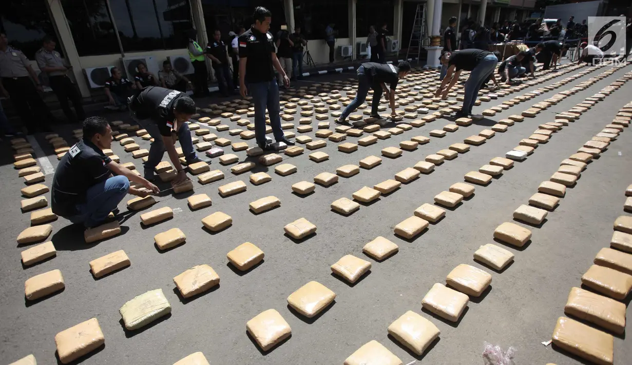 Petugas merapikan barang bukti ganja sebanyak 1.300 paket di Polres Jakarta Barat, Kamis (4/1). Polres Metro Jakbar berhasil menghentikan penyelundupan 1,3 ton ganja dari Provinsi Aceh ke Jakarta. (Liputan6.com/Arya Manggala)
