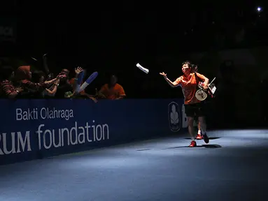 Tontowi Ahmad/Liliyana Natsir ganda campuran Indonesia melemparkan kaus ke arah penonton sebelum dimulainya semifinal BCA Indonesia Open Premier Super Series 2015 di Istora Senayan Jakarta, Sabtu (6/6). (Peksi Cahyo/Bola.com)