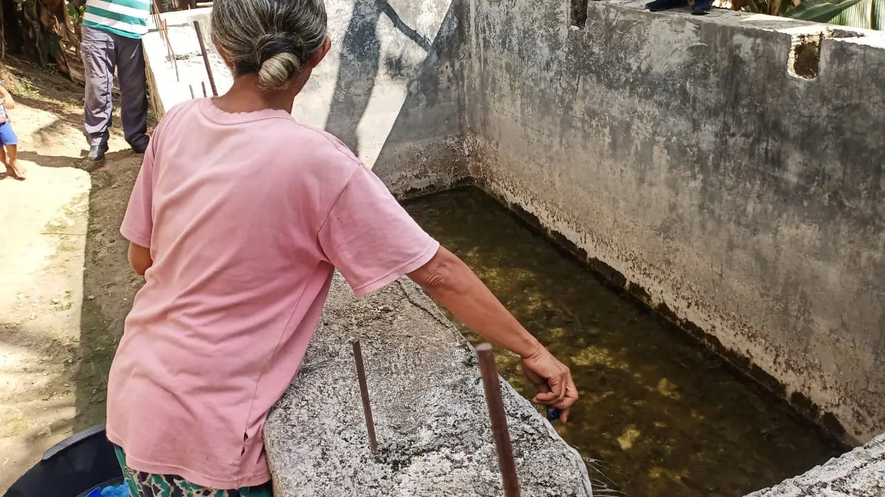 Warga sedang menimbah air tada hujan yang ditampung dalam bak berbulan-bulan dan sudah berlumut. (Liputan6.com/Dionisius Wilibardus)