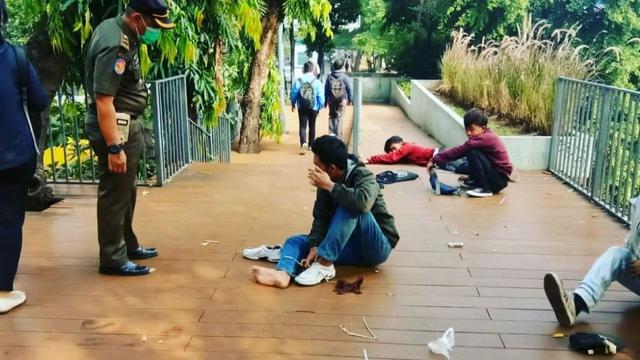 Satpol PP DKI Jakarta membangunkan para remaja yang tertidur