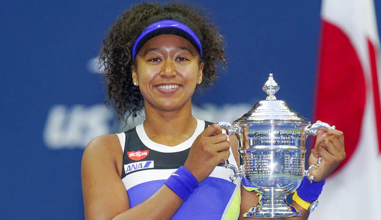 Petenis Jepang, Naomi Osaka, mengangkat trofi usai menjuarai AS Terbuka di Arthur Ashe Stadium, New York, Minggu (13/9/2020). Naomi Osaka mengalahkan Victoria Azarenka 1-6, 6-3, dan 6-3. (AP Photo/Seth Wenig)