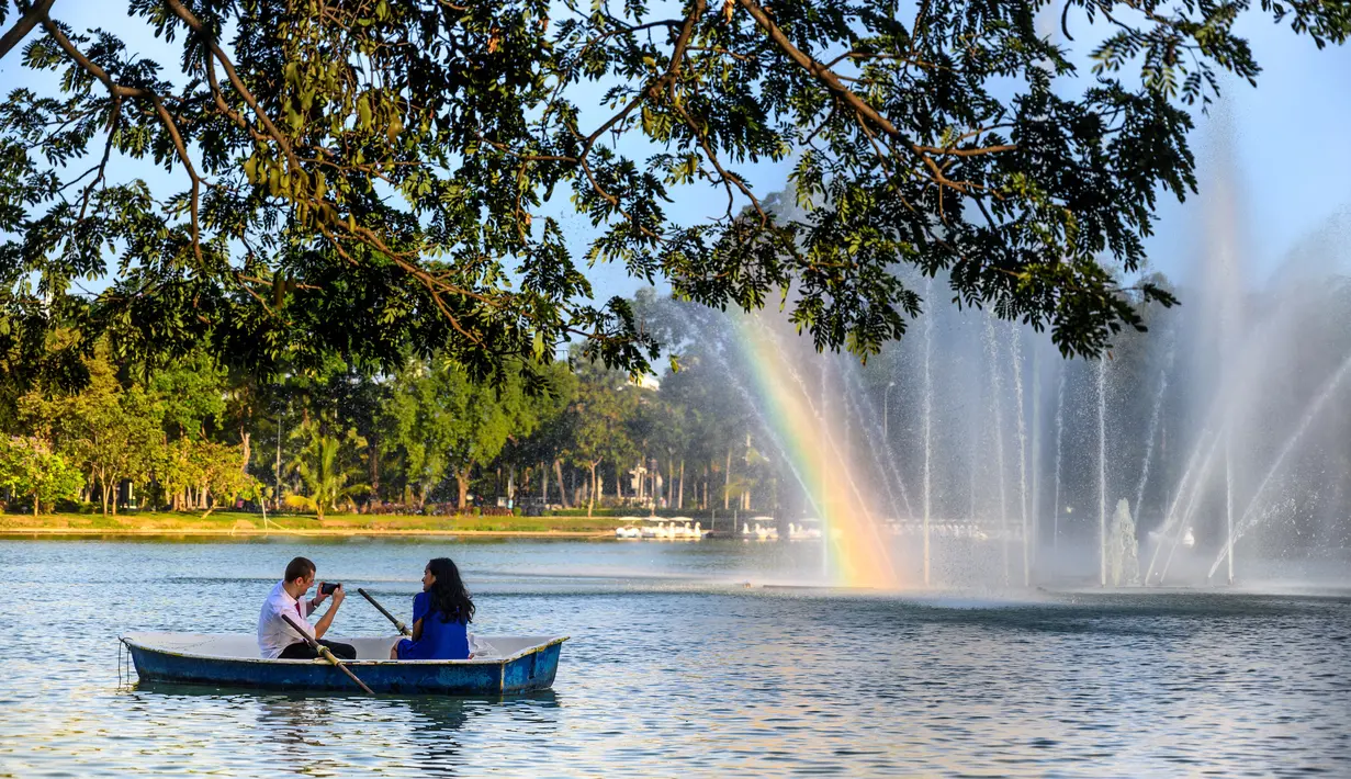 Sepasang suami istri duduk di kapal pada Hari Valentine di danau Taman Lumpini di Bangkok, Thailand, Jumat (14/2/2020). (AFP Photo/Mladen Antonov)
