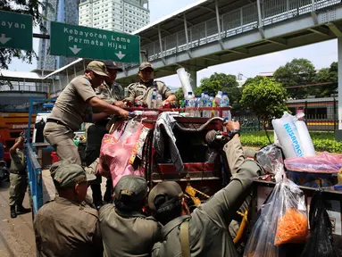 Petugas Satpol PP menertibkan lapak pedagang kaki lima (PKL) di pinggir jalan Kawasan Palmerah, Jakarta, Senin (17/10). Aktifitas ini dilakukan guna membuat jera  pedagang  yang nakal dan tetap nekat berjualan di Bahu jalan. (Liputan6.com/Johan Tallo)