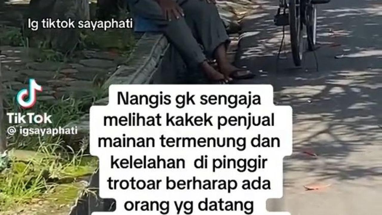 Inilah momen saat kakek penjual mainan duduk termenung di trotoar sambil berharap ada yang membeli dagangannya.