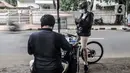Warga memperbaiki kartu tanda penduduk (KTP) melalui jasa servis Feri (28) di Jakarta, Kamis (21/1/2021). Feri mulai membuka jasanya sejak pukul 08.00 WIB hingga 17.00 WIB di pinggir jalan dengan lokasi yang tidak menetap alias berkeliling. (merdeka.com/Iqbal S. Nugroho)