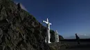 Seorang pria melihat patung penyaliban Kristus di atas tebing di Slea Head jalan di Ventry, Irlandia, Selasa (27/12). Irlandia mendapat julukan Pulau Zamrud karena memiliki pemandangan alam yang hijau terang. (REUTERS / Clodagh Kilcoyne)