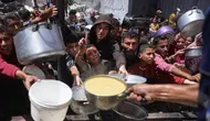 Para pengungsi Palestina berkumpul untuk mengambil makanan yang sudah dimasak dalam sebuah pembagian makanan di Jabalia, Jalur Gaza utara, pada 19 Mei 2025. (Bashar TALEB/AFP)