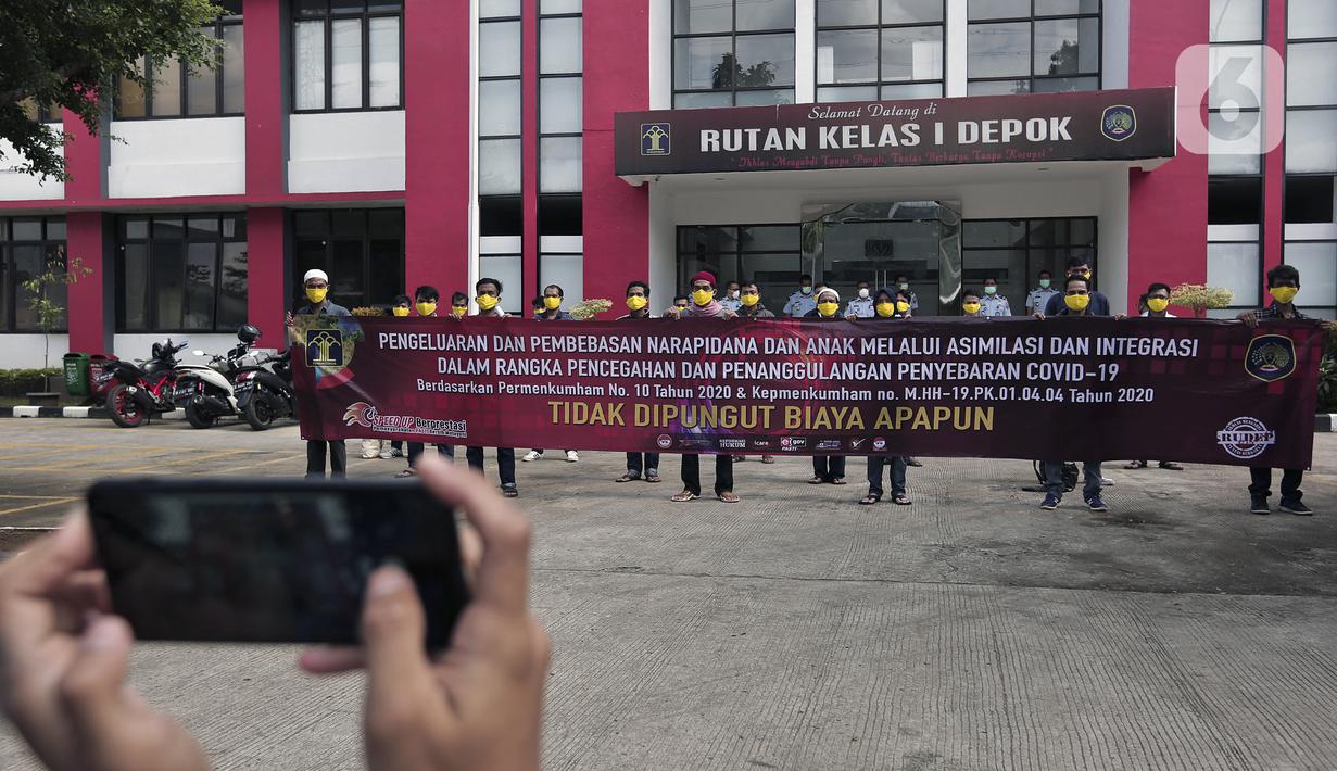 Narapidana foto bersama usai mendapat pembebasan bersyarat melalui program asimilasi dan integrasi terkait pandemi virus corona COVID-19 di Rutan Kelas I Depok, Jawa Barat, Selasa (7/4/2020). Narapidana yang dibebaskan harus sudah menjalani dua pertiga masa tahanan. (Liputan6.com/Johan Tallo)