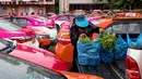 Seorang karyawan bersiap untuk menanam sayuran di atap taksi yang terbengkalai di pool taksi di Bangkok, Thailand, Rabu (15/9/2021). Kehadiran kebun masyarakat unik ini diharapkan dapat menjadi sarana penghilang stres bagi para karyawan di tengah pandemi COivd-19. (Jack TAYLOR/AFP)