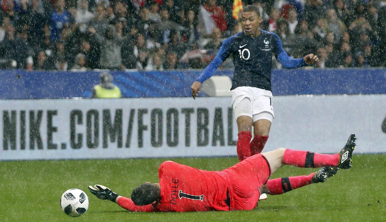 Kiper Irlandia, Colin Doyle, berusaha menghalau tendangan striker Prancis, Kylian Mbappe, pada laga persahabatan di Stadion Stade de France, Senin (28/5/2018). Prancis menang 2-1 atas Irlandia. (AP/Thibault Camus)