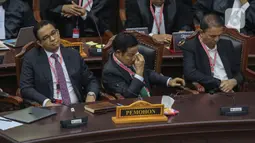 Calon wakil presiden nomor urut 1 Muhaimin Iskandar mengusap wajahnya dengan tisu di sebelah calon presiden Anies Baswedan saat mengikuti jalannya sidang putusan perselisihan hasil Pilpres 2024 di Gedung Mahkamah Konstitusi (MK), Jakarta, Senin (22/4/2024). (Liputan6.com/Angga Yuniar)