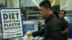 Konsumen membawa barang yang telah dibeli menggunakan kantong plastik di salah satu mini market di Pasar Baru, Jakarta, Senin (22/2). Pemerintah mulai menguji coba penerapan kantong plastik berbayar di ritel modern. (Liputan6.com/Gempur M Surya)