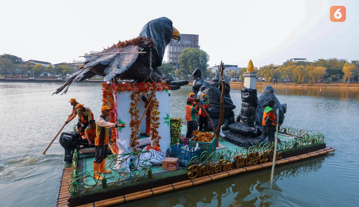 Sejumlah petugas Pasukan Oranye Dinas Lingkungan Hidup (DLH) DKI Jakarta memindahkan perahu berbahan botol plastik bekas berbentuk burung elang untuk ditampilkan dalam Festival Perahu Cinta Lingkungan (CiLung Fest) 2026 di Danau Sunter Selatan, Jakarta Utara, Selasa (13/10/2026). (KLY/Budy Santoso)