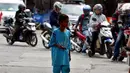 Seorang anak di SPBU Tanjung Pantura - Brebes mengais rejeki untuk membersihakan motor yang di kendarai pemudik dari Jakarta menuju kampung halamannya, Kamis (22/6). (Liputan6.com/Johan Tallo)