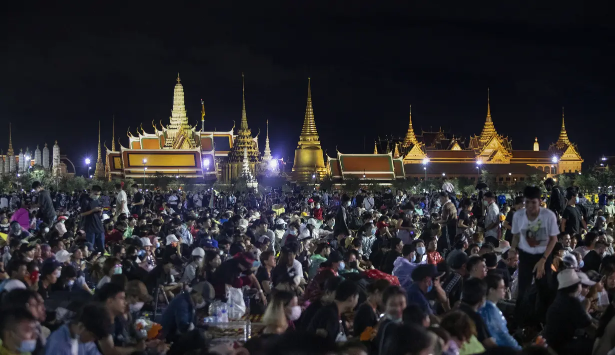 Demonstran pro-demokrasi menghadiri protes di Sanam Luang dengan The Grand Palace menyala di latar belakang di Bangkok, Thailand (19/9/2020). (AP Photo/Sakchai Lalit)