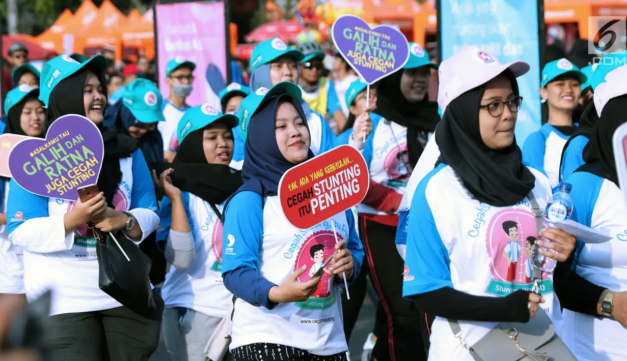 Peserta kampanye cegah stunting membawa tulisan saat berjalan di kawasan Bundaran Hotel Indonesia, Jakarta, Minggu (16/9). Peserta juga bakal memberikan penyuluhan tentang stunting ke masyarakat sekitar. (Liputan6.com/Helmi Fithriansyah)
