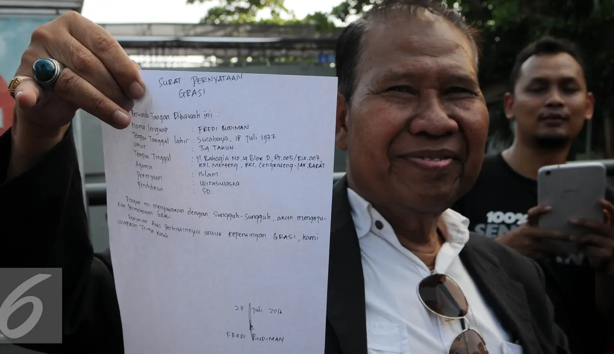 Pengacara Freddy Budiman, Untung Sunaryo menunjukkan surat yang ditulis langsung oleh Freddy Budiman, Cilacap, Jawa Tengah, Rabu (27/7). Menurut pengacaranya, Freddy hanya meminta dimakamkan di tanah kelahirannya (Surabaya). (Liputan6.com/Helmi Afandi)