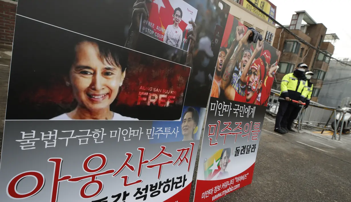 Seorang pria memegang spanduk bergambar pemimpin Myanmar Aung San Suu Kyi saat melakukan protes di depan Kedutaan Besar Myanmar di Seoul, Korea Selatan, Jumat (5/2/2021). Spanduk-spanduk tersebut bertuliskan "Bebaskan Aung San Suu Kyi segera." (AP Photo/Lee Jin-man)