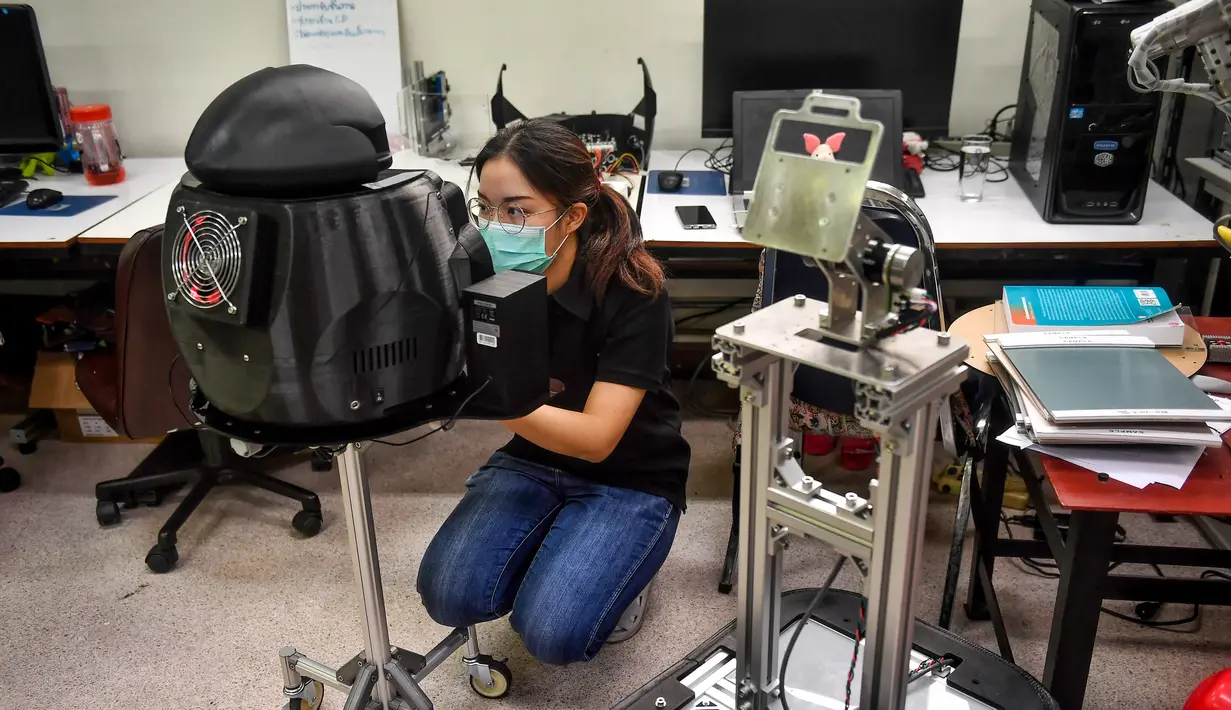 Mahasiswa menonfigurasi robot medis yang dimodifikasi untuk memeriksa pasien virus corona COVID-19 di Regional Center of Robotics Technology, Chulalongkorn University, Bangkok, Thailand, Rabu (18/3/2020). Thailand mengerahkan robot ‘Ninja’ untuk membantu memerangi COVID-19. (LILLIAN SUWANRUMPHA/AFP)