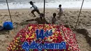 Anggota keluarga menata bunga saat upacara penghormatan untuk korban tsunami tahun 2004 di Pantai Pattinapakkam, Chennai, India, Rabu (26/12). Lebih dari 230 ribu jiwa meninggal dalam tsunami Samudra Hindia pada 2004 lalu. (ARUN SANKAR/AFP)