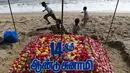 Anggota keluarga menata bunga saat upacara penghormatan untuk korban tsunami tahun 2004 di Pantai Pattinapakkam, Chennai, India, Rabu (26/12). Lebih dari 230 ribu jiwa meninggal dalam tsunami Samudra Hindia pada 2004 lalu. (ARUN SANKAR/AFP)