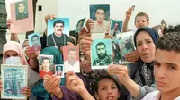 Keluarga-keluarga tersebut mengangkat foto orang yang mereka cintai yang hilang di tengah perang saudara di Aljazair, selama demonstrasi mingguan di Aljir pada bulan September 1998 (Sumber: AFP)