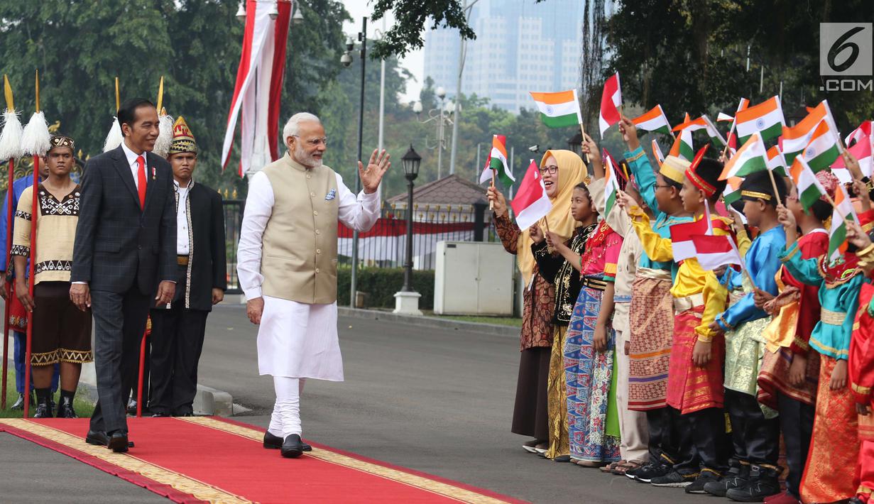Perdana Menteri (PM) India, Narendra Modi didampingi Presiden Joko Widodo (Jokowi) menyapa murid Sekolah Dasar berpakaian adat Indonesia dalam upacara penyambutan di Istana Merdeka, Jakarta, Rabu (30/5). (Liputan6.com/Angga Yuniar)