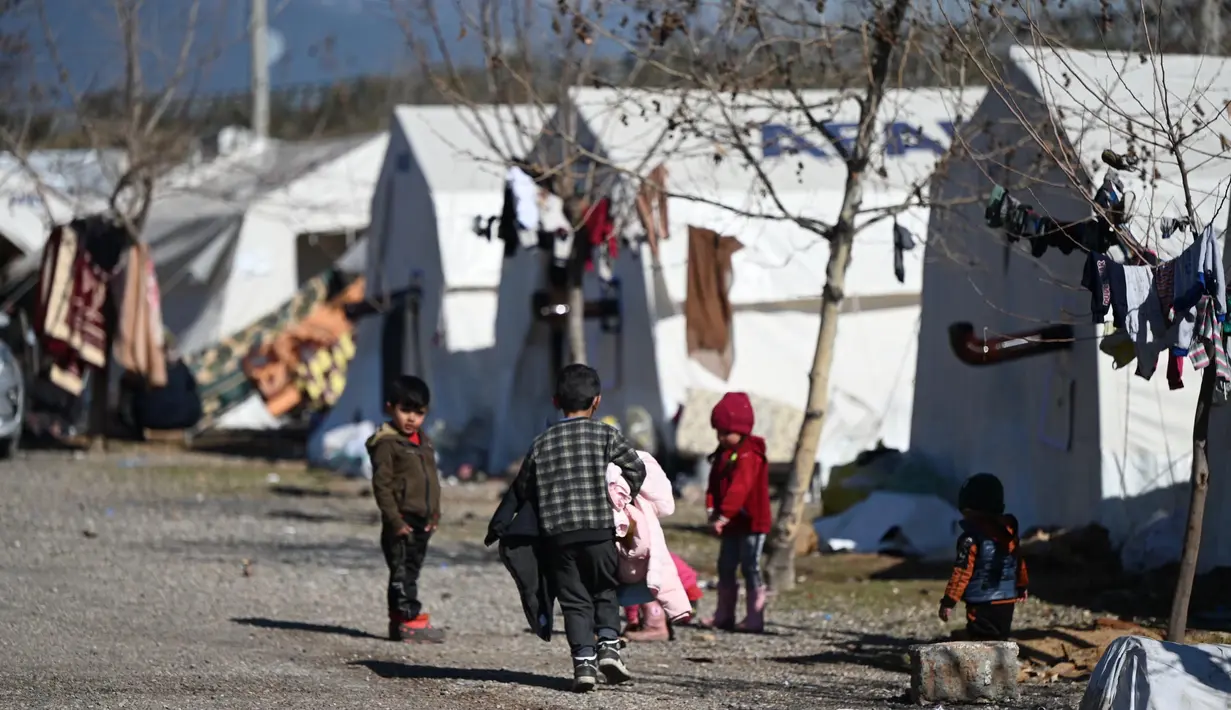 Anak-anak saat berada di sebuah kamp untuk pengungsi Suriah di Turki yang didirikan oleh lembaga bantuan Turki AFAD di distrik Islahiye, Gaziantep, Rabu (15/2/2023). Gempa berkekuatan 7,8 magnitudo yang melanda Turki dan Suriah pada Senin (6/2) kemungkinan akan menjadi salah satu bencana yang paling mematikan dalam dekade ini, ungkap para seismolog. (OZAN KOSE/AFP)