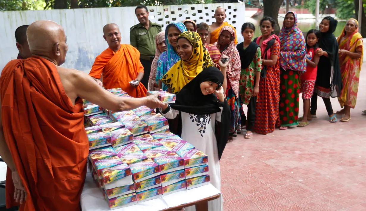 Seorang gadis menerima makanan untuk berbuka puasa yang diberikan biksu di kuil Budha di Dhaka, Bangladesh (9/6). (AP Photo / A.M. Ahad)