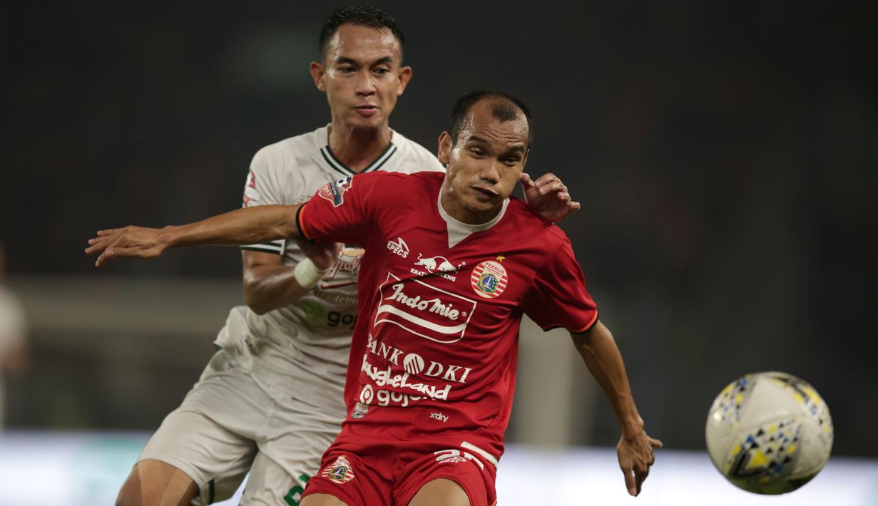 Gelandang Persija Jakarta, Riko Simanjuntak, berebut bola dengan pemain Persebaya pada laga Shopee Liga 1 di SUGBK, Jakarta, Selasa (17/12). Persebaya menang 2-1 atas Persija. (Bola.com/Yoppy Renato)