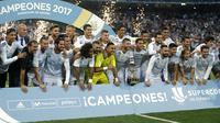 Cristiano Ronaldo (kiri) berfoto bersama timnya saat meraih trofi Piala Super Spanyol 2017 bersama rekannya di Santiago Bernabeu stadium, Madrid, (16/8/2017). Real menang agregat 5-1. (AP/Francisco Seco)
