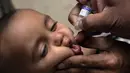 Ekspresi seorang anak saat diberikan vaksin polio oleh pekerja kesehatan di Lahore, Pakistan, (9/4). Pakistan meluncurkan vaksinasi polio baru, yang bertujuan agar 38,7 juta anak di bawah usia 5 tahun mendapatkan vaksin tersebut. (AP Photo/KM Chaudary)