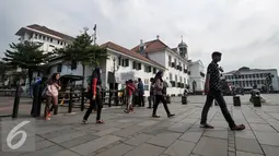 Pejalan kaki melintas di area trotoar Kota Tua, Jakarta, Kamis (4/8). Pemerintah Provinsi DKI Jakarta membuat konsep lingkungan yang ramah bagi pejalan kaki di kawasan Kota Tua sampai Pasar Ikan. (Liputan6.com/Yoppy Renato)