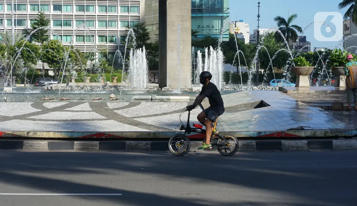 Pesepeda melintas di kawasan Bundaran HI, Jakarta, Minggu (24/5/2020). Adanya PSBB serta Hari Raya Idul Fitri 1441 H dimanfaatkan sebagian warga untuk bersepeda di jalan protokol yang sepi dibanding hari biasa. (Liputan6.com/Immanuel Antonius)