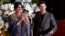 Pasangan aktris Bollywood Priyanka Chopra dan musisi Nick Jonas menyapa fotografer saat resepsi pernikahan mereka di Mumbai, Rabu (19/12). Resepsi kedua Priyanka Chopra dan Nick Jonas digelar dua minggu setelah resepsi yang pertama. (AP/Rajanish Kakade)