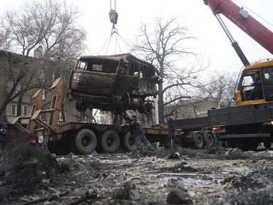 Seorang pria memuat truk militer, yang terbakar selama bentrokan ke peron di Almaty, Kazakhstan, Minggu (9/1/2022). Kementerian Kesehatan Kazakhstan mengatakan setidaknya 164 orang tewas dalam protes yang mengguncang negara itu selama seminggu terakhir. (Vladimir Tretyakov/NUR.KZ via AP)