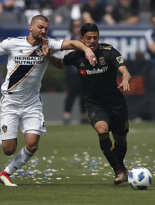 Pemain Los Angeles FC, Carlos Vela (kanan) berebut bola dengan pemain Los Angeles Galaxy, Perry Kitchen pada laga Major League Socccer di StubHub Center,  California, (31/3/2018). LA Galaxy menang 4-3. (AP/Jae C. Hong)