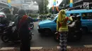 Personel Polisi Wanita (Polwan) Polres Jakarta Timur mengenakan pakaian kebaya saat mengatur arus lalu lintas di Jalan Otista Raya, Jatinegara, Jumat (20/4). Kegiatan tersebut dilakukan dalam rangka memperingati Hari Kartini. (Merdeka.com/Imam Buhori)