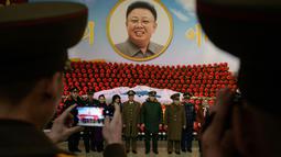 Tentara dari Rusia, Iran dan China dan Korea Utara berpose di depan pajangan selama pameran bunga 'Kimjongilia' di Pyongyang, Kamis (14/2). Korea Utara menggelar festival bunga merayakan ulang tahun mendiang ayah Kim Jong-un, Kim Jong-il.. (Ed JONES/AFP)