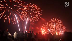 Pengunjung menyaksikan pesta kembang api saat malam Tahun Baru 2019 di Pantai Lagoon, Ancol, Jakarta, Selasa (1/1). Ancol menyajikan pesta kembang api musikal sepanjang 600 meter di bibir pantai dalam menyambut Tahun Baru 2019. (Merdeka.com/Iqbal Nugoho)