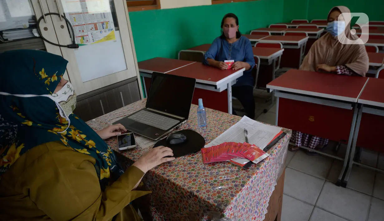 Guru membagikan dua kartu perdana Tri dan Telkomsel beserta kuota gratis kepada wali murid di SDN Serua Indah 1 dan II, Ciputat, Tangerang Selatan, Senin (15/9/2020). Program Kartu Perdana tersebut untuk mendukung kegiatan belajar secara online di masa pandemi covid-19. (merdeka.com/Dwi Narwoko)