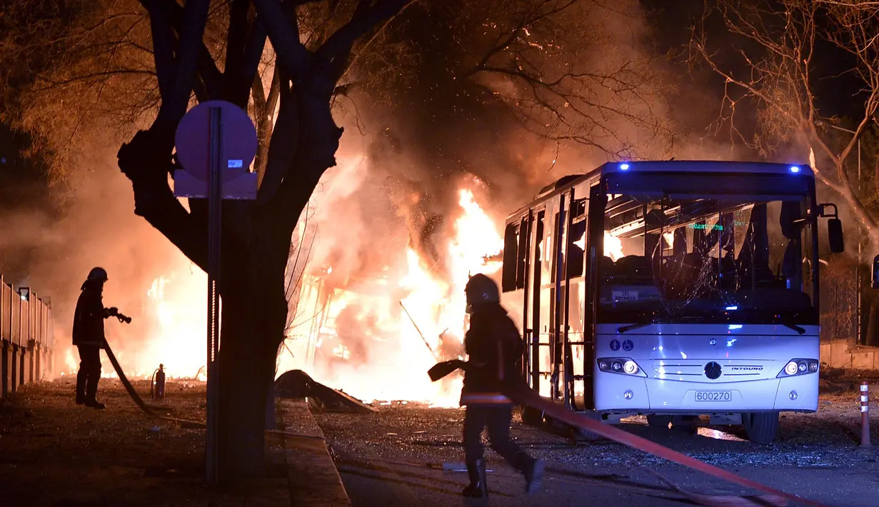 Petugas pemadam bersiap memadamkan api setelah ledakan bom mobil di Ankara, Turki, Rabu (17/2). Bom mobil yang meledak ketika iring-iringan bus militer tengah lewat tersebut menewaskan setidaknya 28 orang.  (REUTERS/Ihlas News Agency TURKEY OUT)