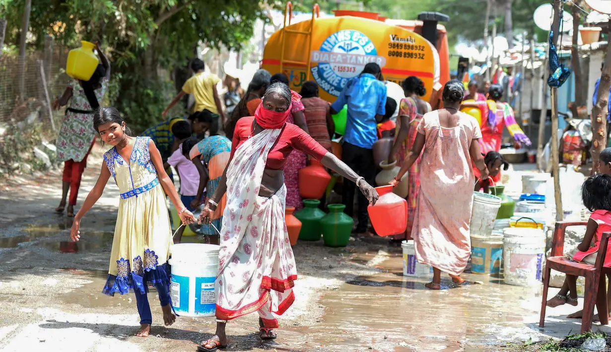 Warga membawa air bersih bantuan pemerintah dalam wadah plastik di perkampungan kumuh di Secunderabad, Hyderabad, India, Rabu (20/5/2020). Gelombang panas membuat negara berpenduduk 1,3 miliar tersebut mengalami krisis air bersih. (NOAH SEELAM/AFP)