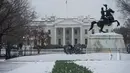 Gedung Putih terlihat dari Lafayette Square di Washington, DC, saat badai salju, Selasa (14/3). Badai salju menerjang kawasan Amerika Serikat timur laut, dari West Virginia hingga Maine, menyebabkan hujan salju lebat di sejumlah tempat (NICHOLAS KAMM/AFP)
