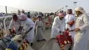 Para pawang mempersiapkan unta untuk balapan pada Festival Unta Putra Mahkota di Kota Taif, Arab Saudi, Rabu (11/8/2021). Selain mempromosikan warisan balap unta Arab Saudi, festival ini juga berupaya untuk mendukung pariwisata dan pembangunan ekonomi. (Amer HILABI/AFP)