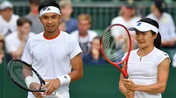 Petenis Indonesia Christopher Rungkat dan Shuko Aoyama dari Jepang bersiap melawan petenis Kroasia Nikola Mektic dan Alicja Rosolska dari Polandia pada putaran kedua ganda campuran Wimbledon 2019 di All England Lawn Tennis Club, Senin (8/7/2019). Christo/Aoyama kalah 5-7, 4-6. (GLYN KIRK/AFP)