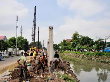 Sejumlah pekerja tengah menggarap proyek pembangunan turap Kali Utan Kayu, Jakarta, Selasa (17/6/14). (Liputan6.com/Faizal Fanani)