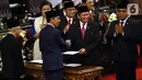 Joko Widodo atau Jokowi (kedua kiri) menyerahkan berkas kepada Ketua MPR Bambang Soesatyo saat dilantik menjadi Presiden RI periode 2019-2024 di Gedung Nusantara, Jakarta, Minggu (20/10/2019). Jokowi dan Ma'ruf Amin resmi menjadi Presiden dan Wakil Presiden RI. (Liputan6.com/JohanTallo)