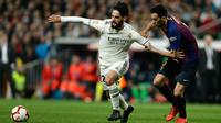 Gelandang Real Madrid, Isco membawa bola dari kawalan gelandang Barcelona, Sergio Busquets selama pertandingan lanjutan La Liga Spanyol di Santiago Bernabeu, Madrid (2/3). Barcelona menang tipis atas Real Madrid 1-0. (AP Photo/Manu Fernandez)